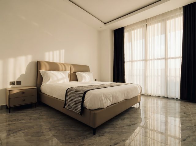 Master bedroom with bronze-upholstered bed in warm afternoon light
