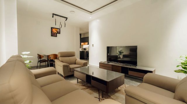 Living room with sofas, walnut coffee table, and a view into the kitchen